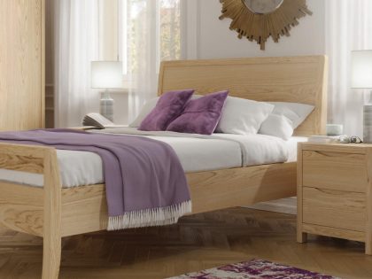 Light colour wooden bed frame with mattress and purple accessories.