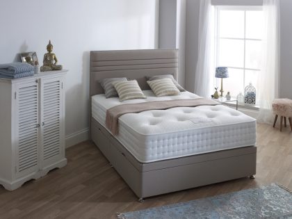 An ottoman storage divan set with horizontal stripe headboard and uncovered mattress, in a bedroom setting.