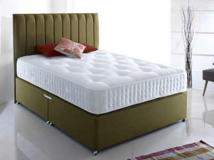 An uncovered mattress sitting on a green divan set with a matching colour vertical stripe headboard, in a white bedroom setting.